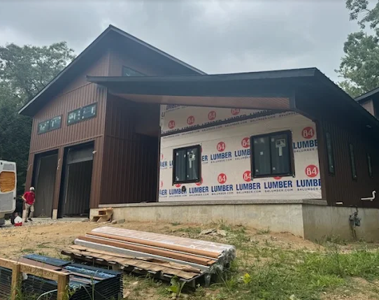 Large custom building receiving new vertical siding and windows